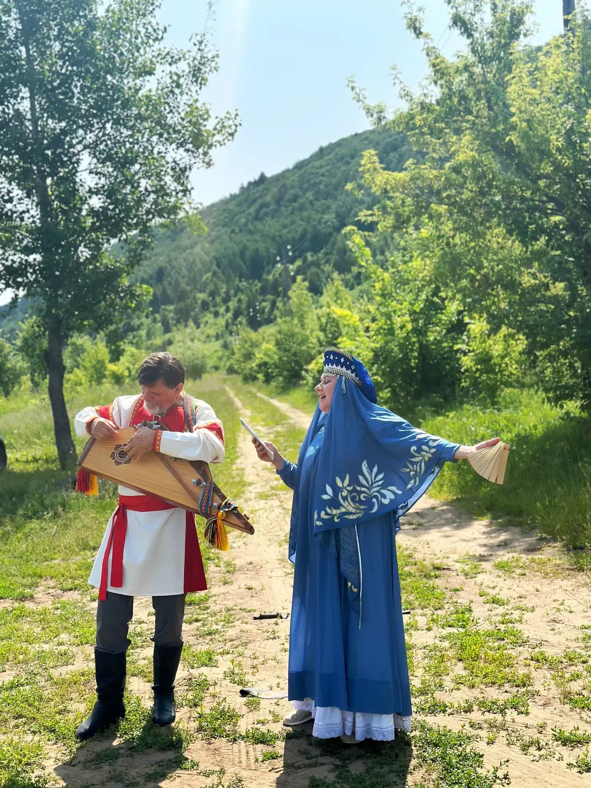 Певица и гусляр в народных костюмах в Ширяево
